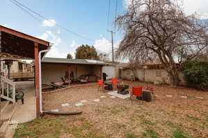 Fenced backyard featuring a patio area and fire pit.