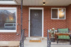 Doorway to property featuring brick siding and a mountain view
