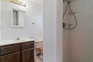 Bathroom with vanity and tiled shower