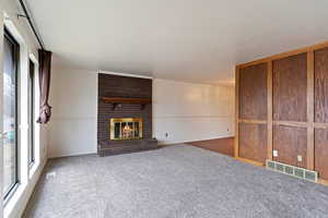 Unfurnished living room with a gas fireplace and carpet