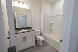 Bathroom featuring vanity, tub / shower combination, and dark tile patterned floors