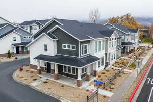 View of front of house featuring a porch, roof with shingles, and a residential view