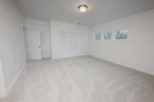 Unfurnished bedroom featuring light carpet and baseboards