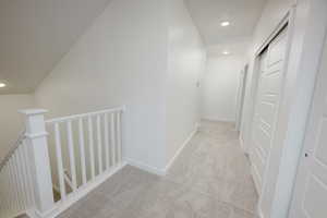 Hall featuring recessed lighting, light colored carpet, and an upstairs landing
