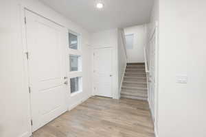Entryway featuring stairs and light wood-style floors