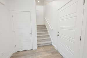 Stairway featuring wood finished floors and baseboards