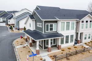 View of front facade featuring a porch, a shingled roof, and a residential view
