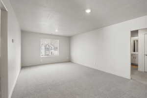 Unfurnished room with light carpet, a textured ceiling, and recessed lighting