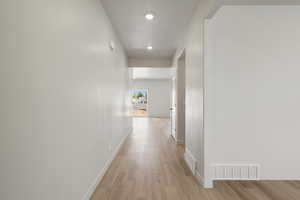 Hallway featuring light wood-style flooring and baseboards