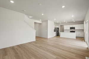 Unfurnished living room featuring light wood-style flooring and recessed lighting