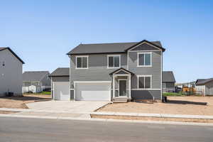 View of front of property featuring concrete driveway, board and batten siding, a garage, and a residential view