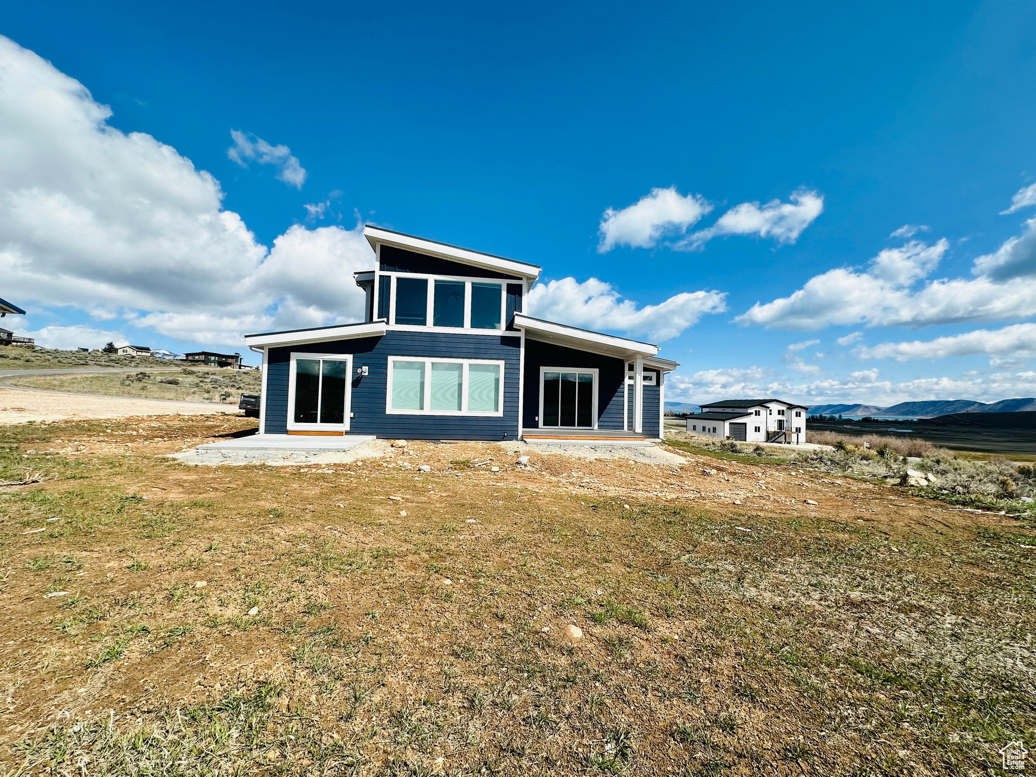 Rear view of house featuring a mountain view and a patio area