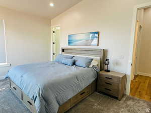 Bedroom featuring dark carpet, lofted ceiling, and recessed lighting