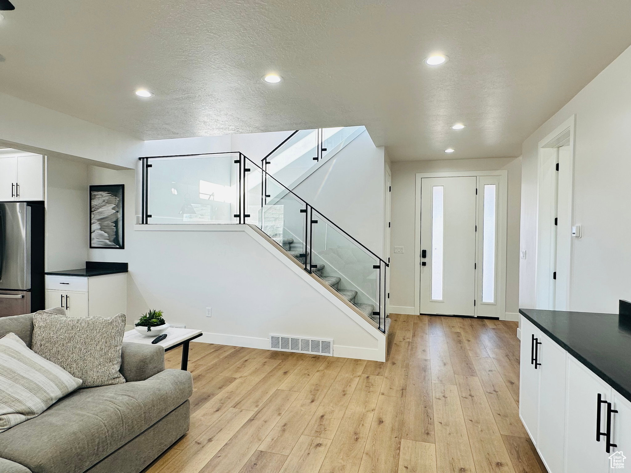 Living area featuring light wood-style floors and recessed lighting