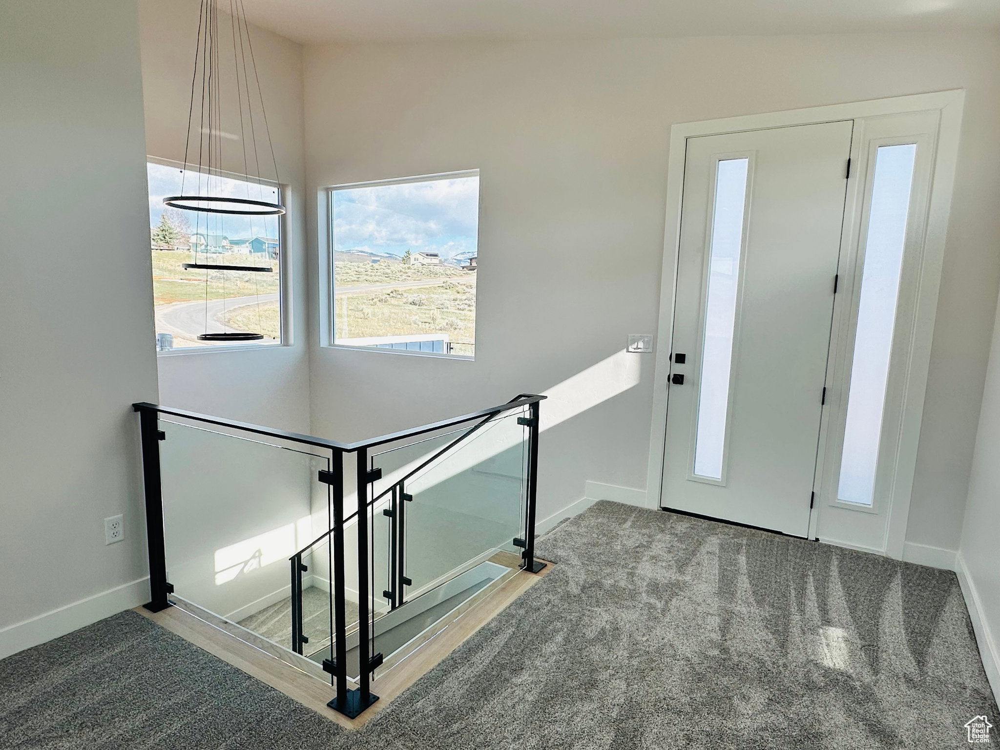 Foyer entrance featuring carpet floors and baseboards