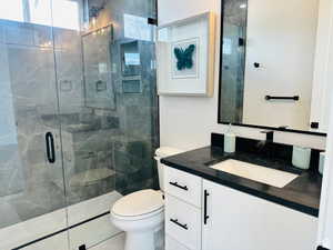 Full bathroom featuring a shower stall and vanity