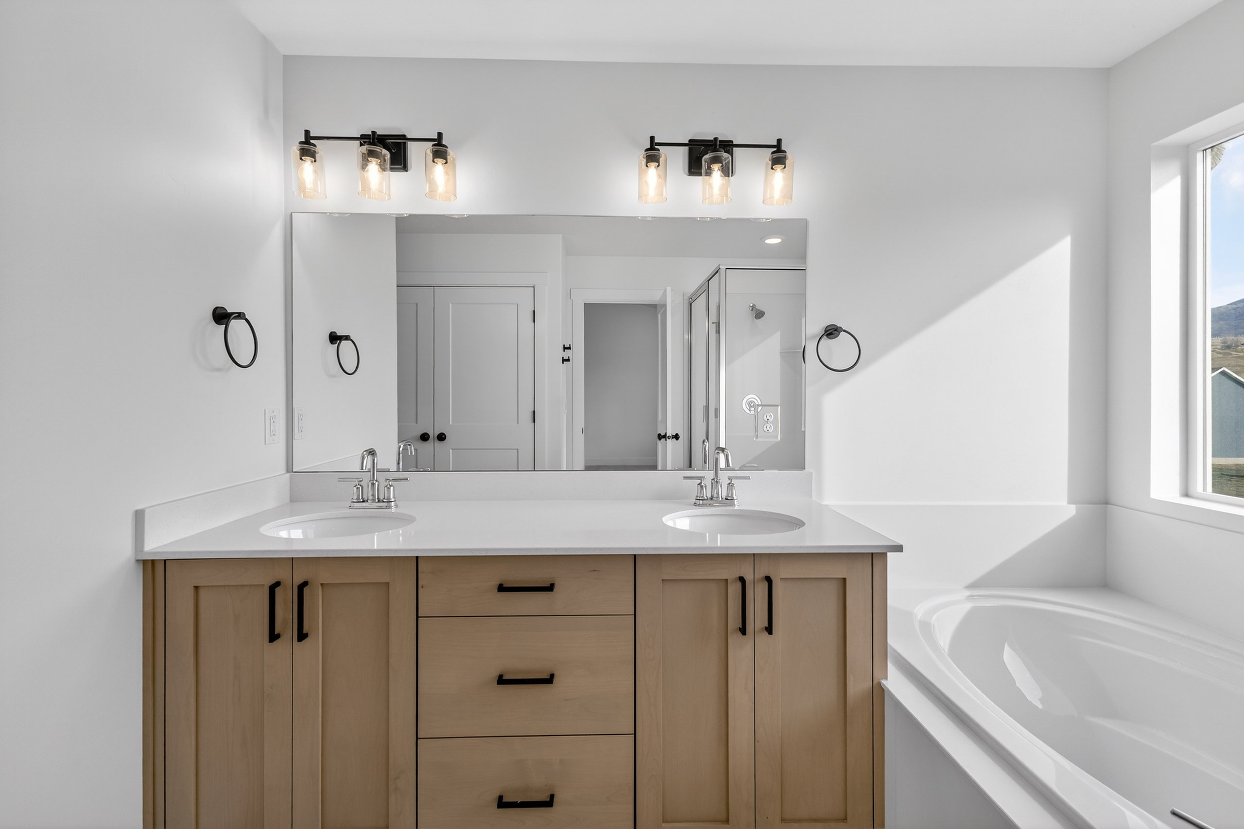 Bathroom with double vanity, a garden tub, and a shower stall