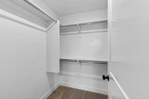 Walk in closet featuring dark carpet