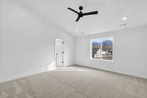 Carpeted empty room with ceiling fan, lofted ceiling, and recessed lighting