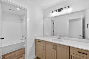 Bathroom featuring vanity,  shower combination, light wood-type flooring, and recessed lighting