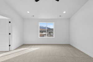 Empty room with light carpet, a ceiling fan, a mountain view, and recessed lighting