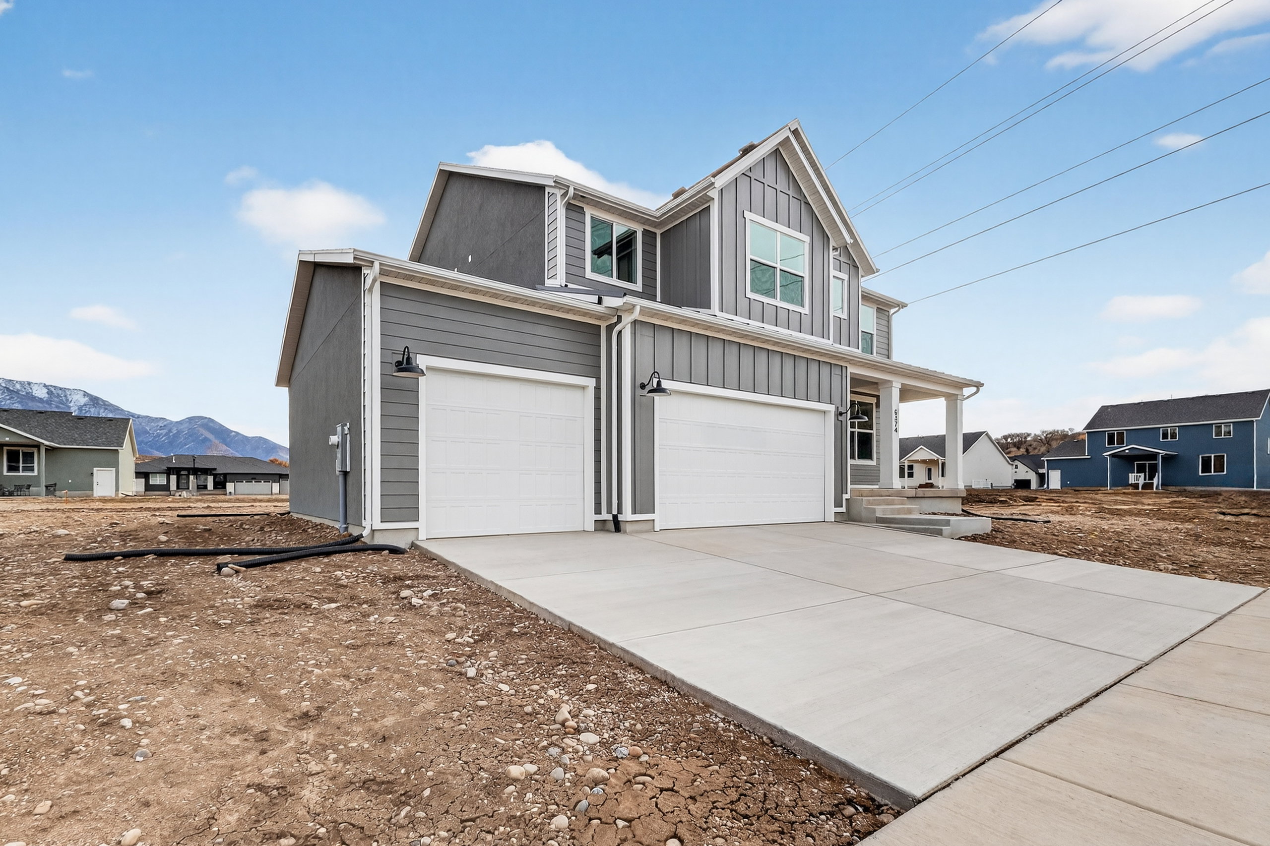 View of front of house featuring an attached garage, board and batten siding, driveway, and a porch