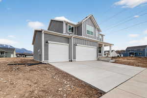 View of front of house featuring an attached garage, board and batten siding, driveway, and a porch