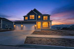 View of front of property with board and batten siding, concrete driveway, and a porch