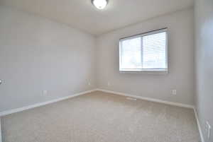 Bedroom with light carpet and baseboards