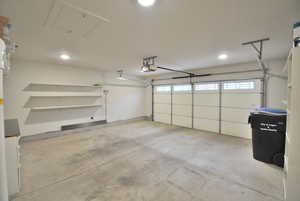 Garage with recessed lighting and a garage door opener