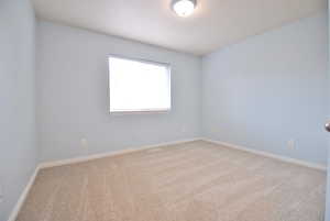 Bedroom with light carpet and baseboards