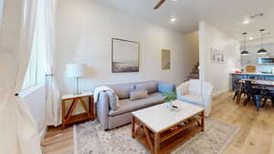 Living room with light wood-type flooring, a ceiling fan, and recessed lighting