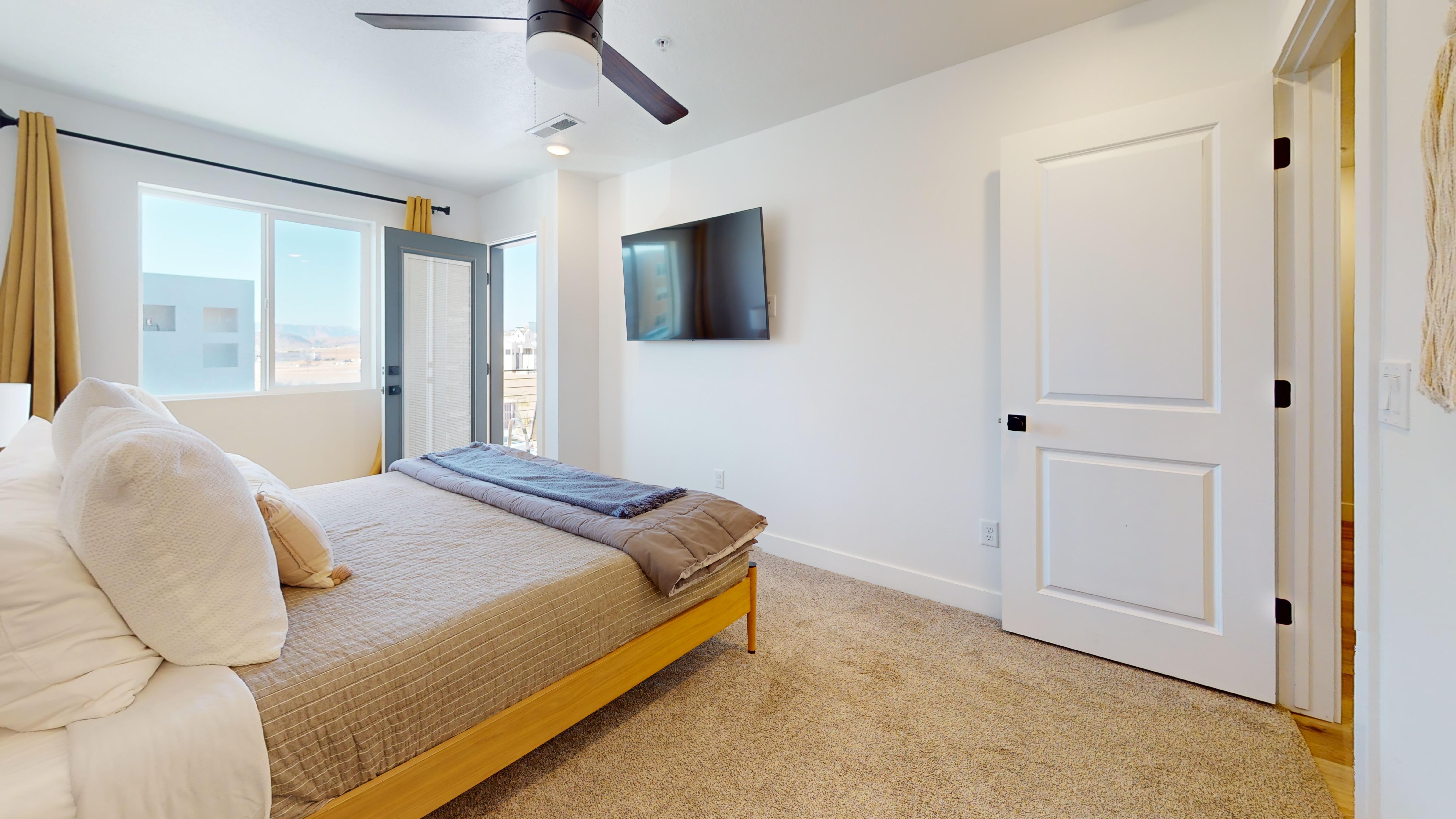 Bedroom featuring access to outside, light carpet, and a ceiling fan
