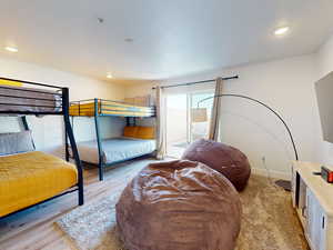 Bedroom with recessed lighting, access to exterior, and light wood-style floors