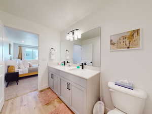 Ensuite bathroom with double vanity and light wood-style floors
