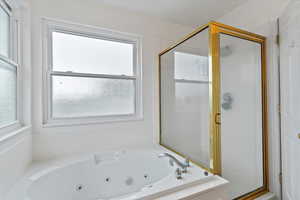 Large jetted tub, separate shower, and vanity with cultured marble surround