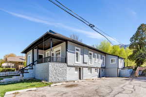 View of front of home featuring stucco siding, an attached garage, and stone siding