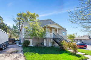 View of front of property with stone siding and a front lawn