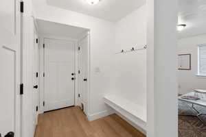 Mudroom with light wood-style flooring and baseboards