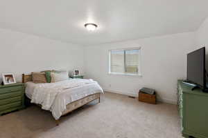 Bedroom featuring light colored carpet and baseboards