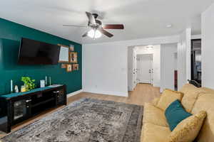 Living room featuring light wood-style flooring and a ceiling fan