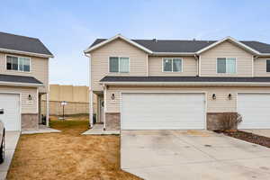 Traditional-style home with brick siding, concrete driveway, and a garage