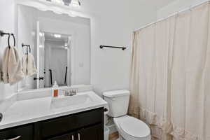Bathroom with a shower with shower curtain and vanity