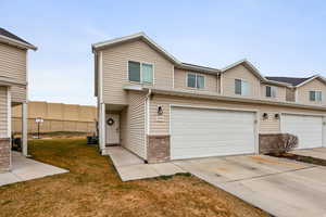 Traditional-style house with brick siding, driveway, a garage, and a front yard