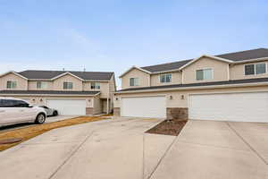 View of front of home featuring concrete driveway, an attached garage, and brick siding