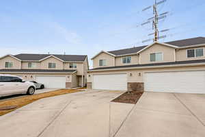 View of front of property featuring concrete driveway, brick siding, and an attached garage