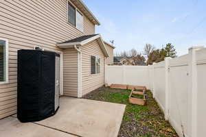 Fenced backyard with a patio area and a vegetable garden