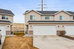 Traditional home featuring driveway, brick siding, an attached garage, and a shingled roof