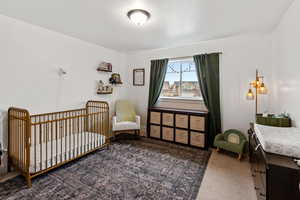 Carpeted bedroom with a nursery area and a textured ceiling