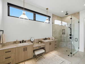 Bathroom featuring two vanities, a shower stall, and recessed lighting